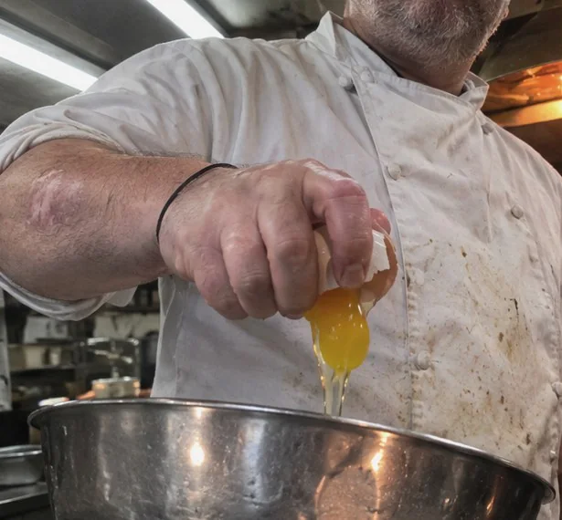 A chef cracking an egg into a bowl, with hand landmarks traced
