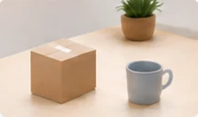 A box, a mug and a plant on a table